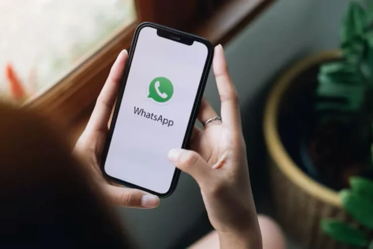 O botão 'escondido' no seu WhatsApp que libera espaço na memória sem apagar suas fotos 1 Pessoa segurando celular com o logo do WhatsApp na tela, mostrando a funcionalidade para liberar espaço sem apagar fotos.