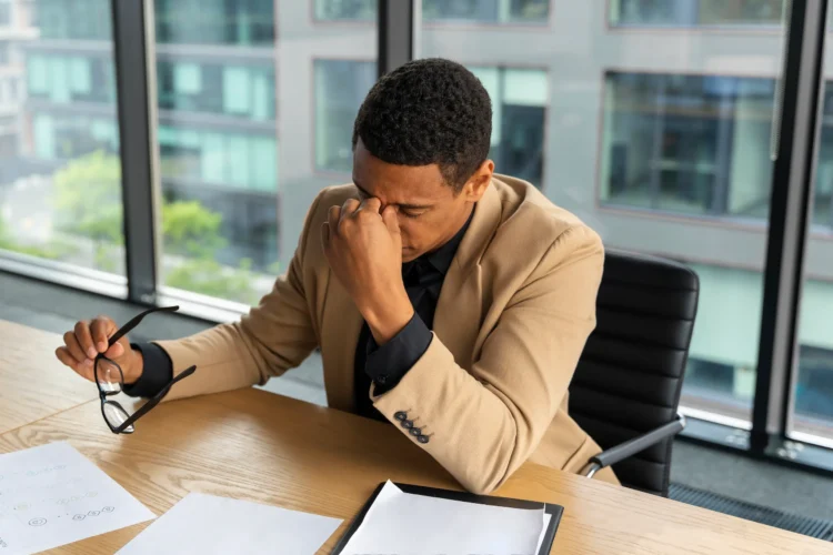O erro nº 1 que profissionais de sucesso pararam de cometer (e você ainda faz) 1 Profissional com expressão de frustração em um escritório, refletindo sobre seus erros no trabalho