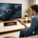 Homem sentado no sofá enfrentando buffering ao assistir streaming em smart TV