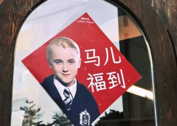 Imagem de Draco Malfoy, personagem de Harry Potter, em um cartaz com fundo vermelho, destacado como símbolo de sorte e festa na cultura chinesa.