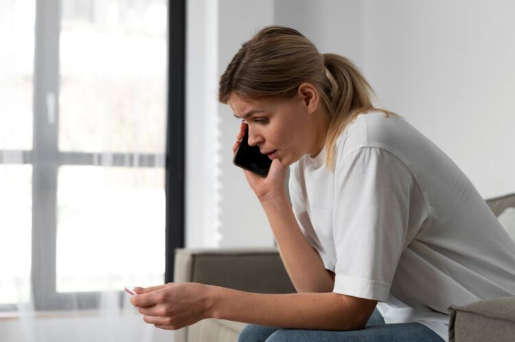 Ligue 180 pode virar alerta obrigatório em notícias de violência contra a mulher; saiba mais 1 Mulher preocupada e conversando ao telefone, em um ambiente doméstico, representando a importância de denunciar casos de violência contra a mulher.