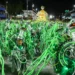 Integrantes desfilam com fantasias verdes e prateadas repletas de tubos luminosos na avenida