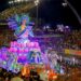 Carnaval SP 2026: confira a programação completa dos desfiles das escolas de samba 12 Imagem noturna do Sambódromo do Anhembi em São Paulo durante o Carnaval. Um suntuoso carro alegórico em tons de azul e roxo apresenta uma escultura gigante de uma sereia com as mãos postas, cercada por cavalos-marinhos e iluminação neon vibrante.