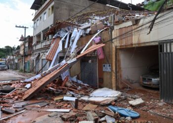 Estrutura de casa desabada e escombros ocupando calçada após enchente em Minas Gerais