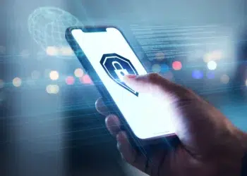 Mão toca smartphone exibindo ícone de cadeado em destaque