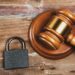 Martelo de juiz e cadeado sobre uma mesa de madeira, representando a regulamentação de dados no Brasil.