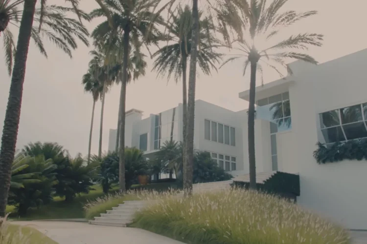 Mansão de Ana Hickmann será leiloada por R$ 35 milhões 1 Mansão branca de dois andares cercada por palmeiras e jardim bem cuidado