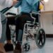 Paciente em cadeira de rodas durante atendimento clínico, representando estudos sobre recuperação de movimentos em pessoas tetraplégicas.