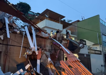 Rua Nicolau Capelli com acúmulo de água após forte chuva, dificultando a passagem de veículos e pedestres.