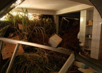 Terra, lama e destroços de móveis cobrem cozinha após deslizamento causado por fortes chuvas