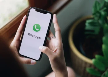 Aplicativo WhatsApp aberto em smartphone exibindo nova identidade visual com possível mudança de cor e ícone.