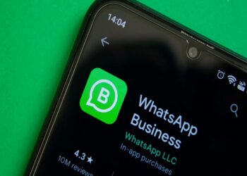 Smartphone exibe tela inicial do WhatsApp Business com destaque para o logo e avaliações.