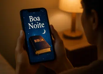 Pessoa segurando celular com mensagem 'Boa Noite' e imagem da Bíblia na tela