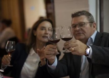 Casal brindando com taças de vinho tinto