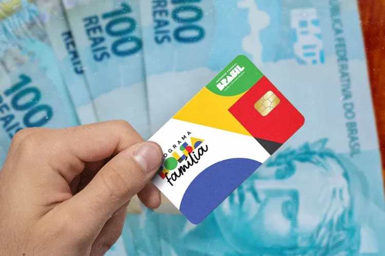 Bolsa Família de março pode cair antes nessas 58 cidades; veja a pré-lista oficial 2 Mão segura cartão do Bolsa Família sobre várias notas de 100 reais dispostas