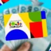 Cartão do Programa Bolsa Família com cédulas de reais ao fundo