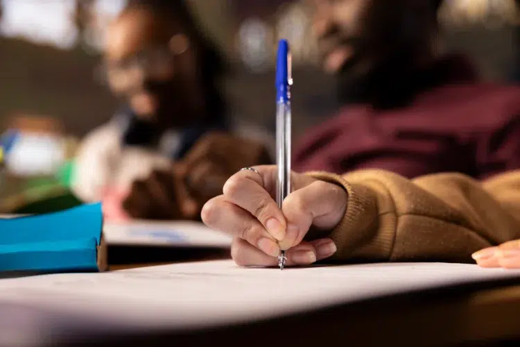 Validade do Concurso Nacional Unificado 1º edição ganha mais um ano de prorrogação 2 Pessoa com caneta azul escreve em folha durante preparação para concurso público
