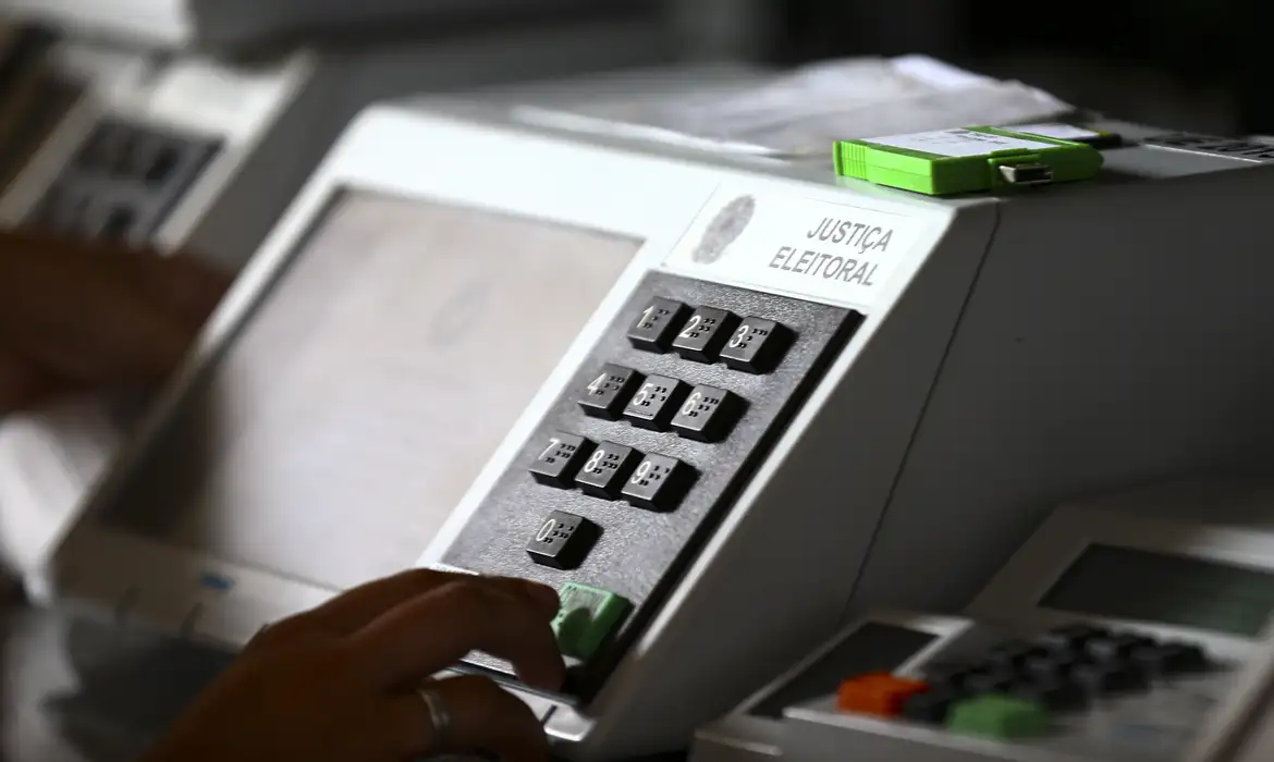Eleições 2026: TSE volta a debater regras importantes nesta segunda-feira 2 Urna eletrônica durante votação, símbolo das regras que estão sendo debatidas pelo TSE para as Eleições 2026.