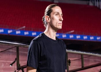 Técnico do Flamengo com expressão séria em estádio vazio usando camisa preta enquanto observa o campo.