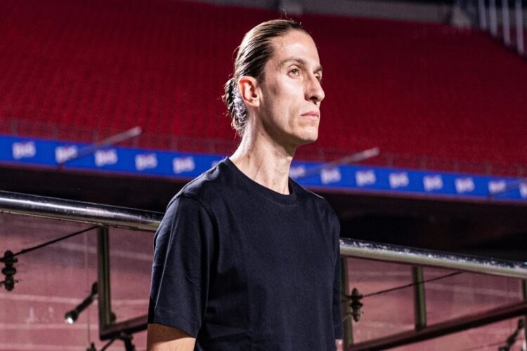 Goleada contra o Madureira não impede demissão de Filipe Luís pelo Flamengo 1 Técnico do Flamengo com expressão séria em estádio vazio usando camisa preta enquanto observa o campo.