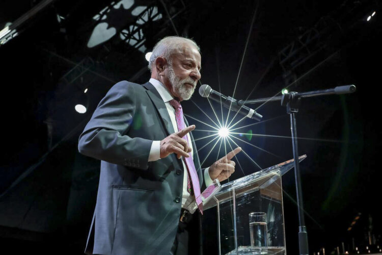 Fim da escala 6x1: Governo Lula defende nova fórmula de negociação com patrões e empregados 2 Presidente Lula de terno discursando em púlpito iluminado, defendendo mudanças nas relações de trabalho