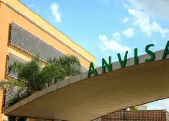 Prédio da Anvisa com letreiro verde e céu azul ao fundo