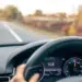 Volante e painel digital marcam 108 km/h em estrada arborizada