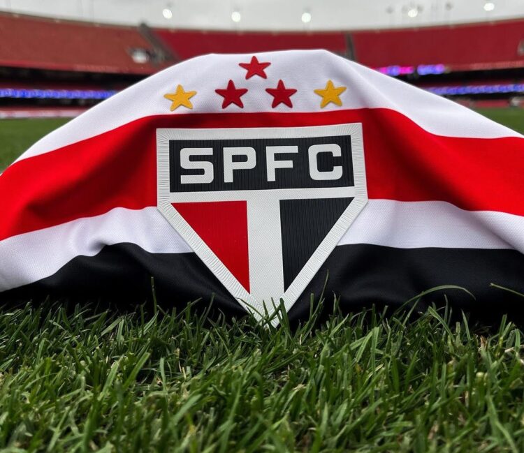 Mudança no São Paulo! Roger Machado assume o comando após demissão de Crespo 2 Escudo do São Paulo FC estampado em camiseta apoiada na grama do estádio