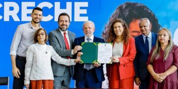 Lula exibe documento ao lado de Guilherme Boulos, Esther Dweck e outras autoridades em cerimônia no Planalto