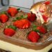 Sobremesa de travessa com camadas cremosas, morangos frescos e raspas de chocolate ao leite