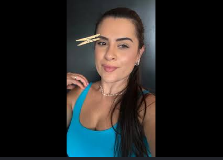 Truque viral do pregador na sobrancelha alivia enxaqueca? Entenda o que a ciência diz 2 Mulher de cabelo escuro usa pregador de madeira na sobrancelha, regata azul turquesa e colar dourado