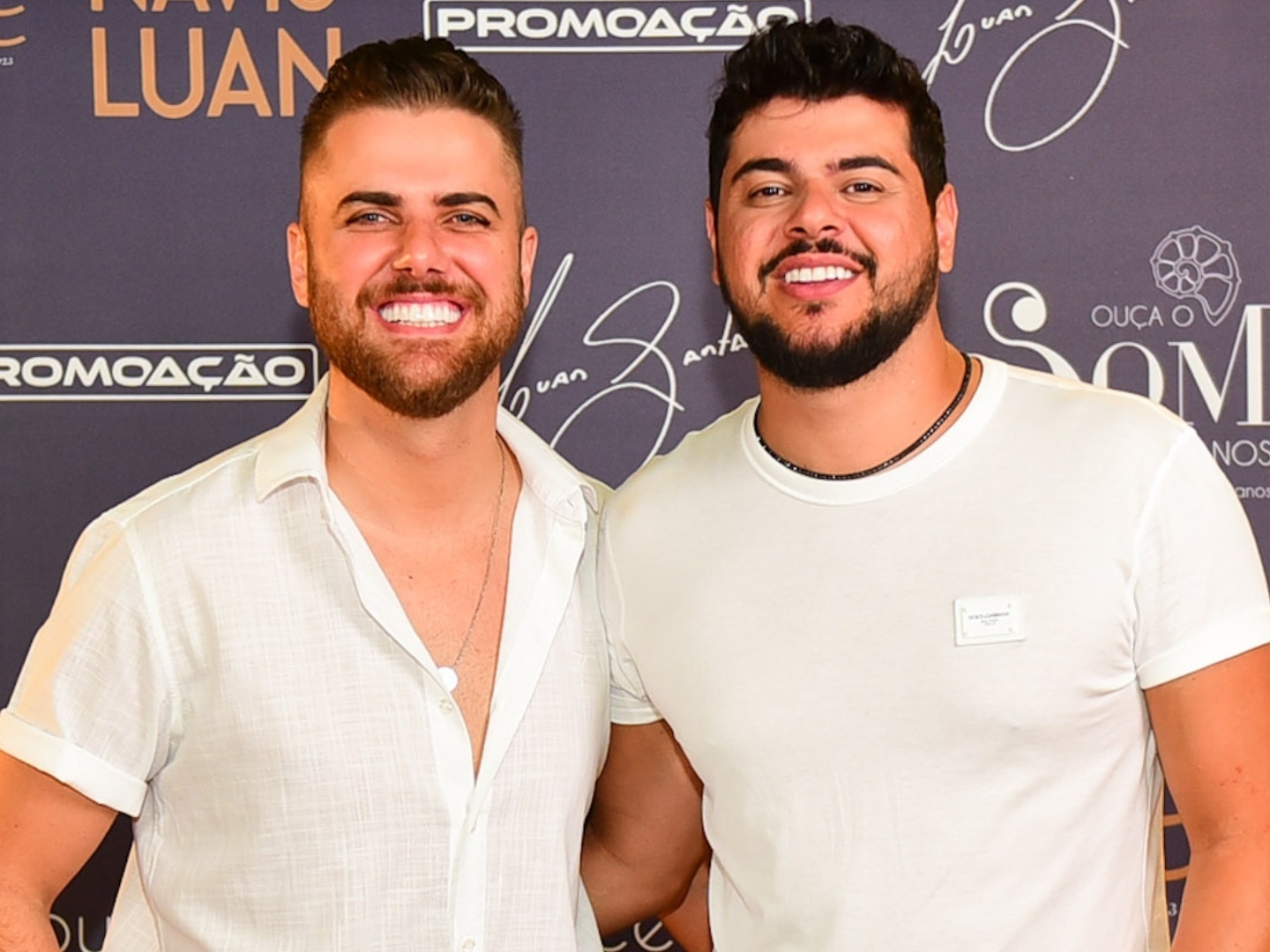 Zé Neto e Cristiano são proibidos judicialmente de divulgar vídeo ligado a Vorcaro 2 Zé Neto e Cristiano sorrindo lado a lado em frente a painel promocional, ambos vestindo roupas claras